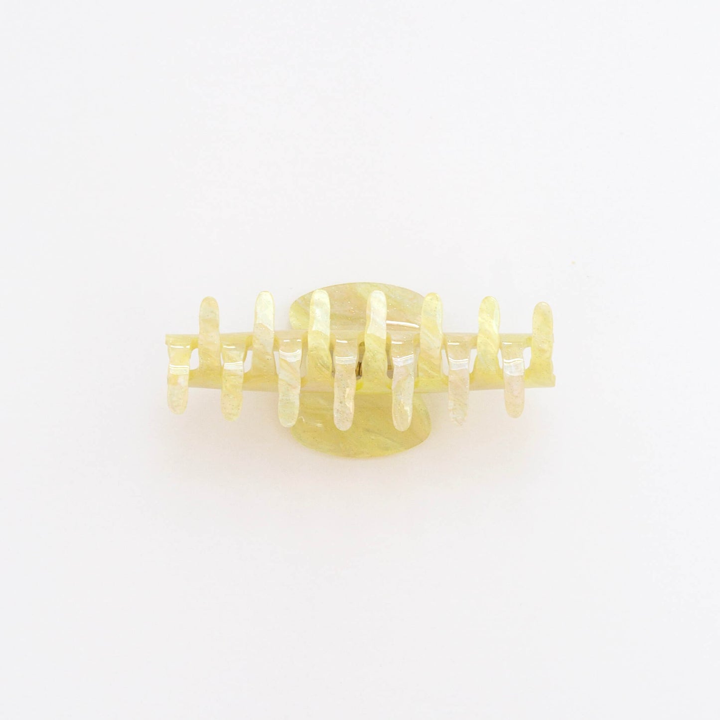A pale yellow tmarble and sparkly hair claw clip, shown from the side against a plain white background.