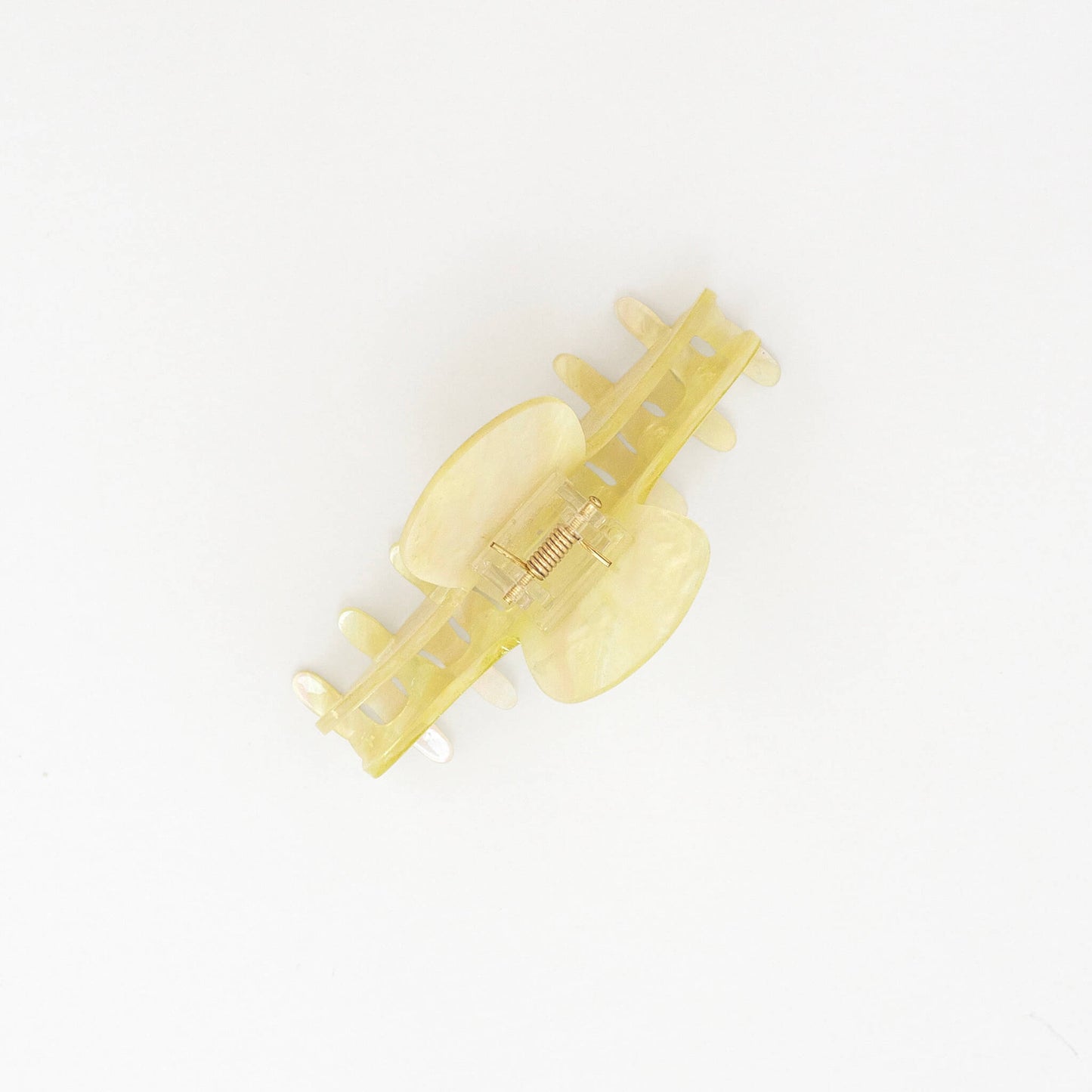 A marbled and sparkly translucent pale yellow hair claw clip on a clean white background.