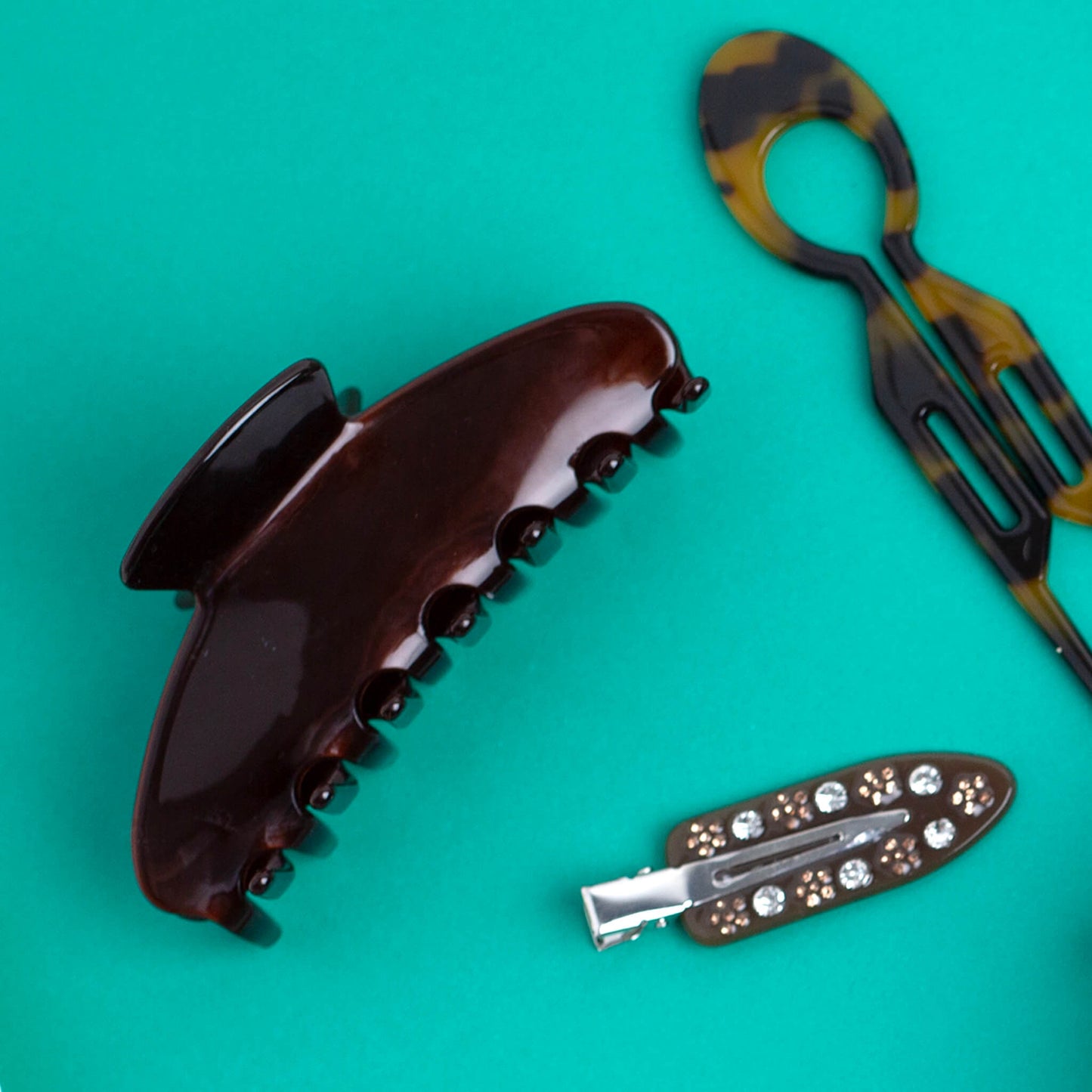 THOC Cove NO crease clip, Camille hair pin and Sloane claw clip on a jade green background