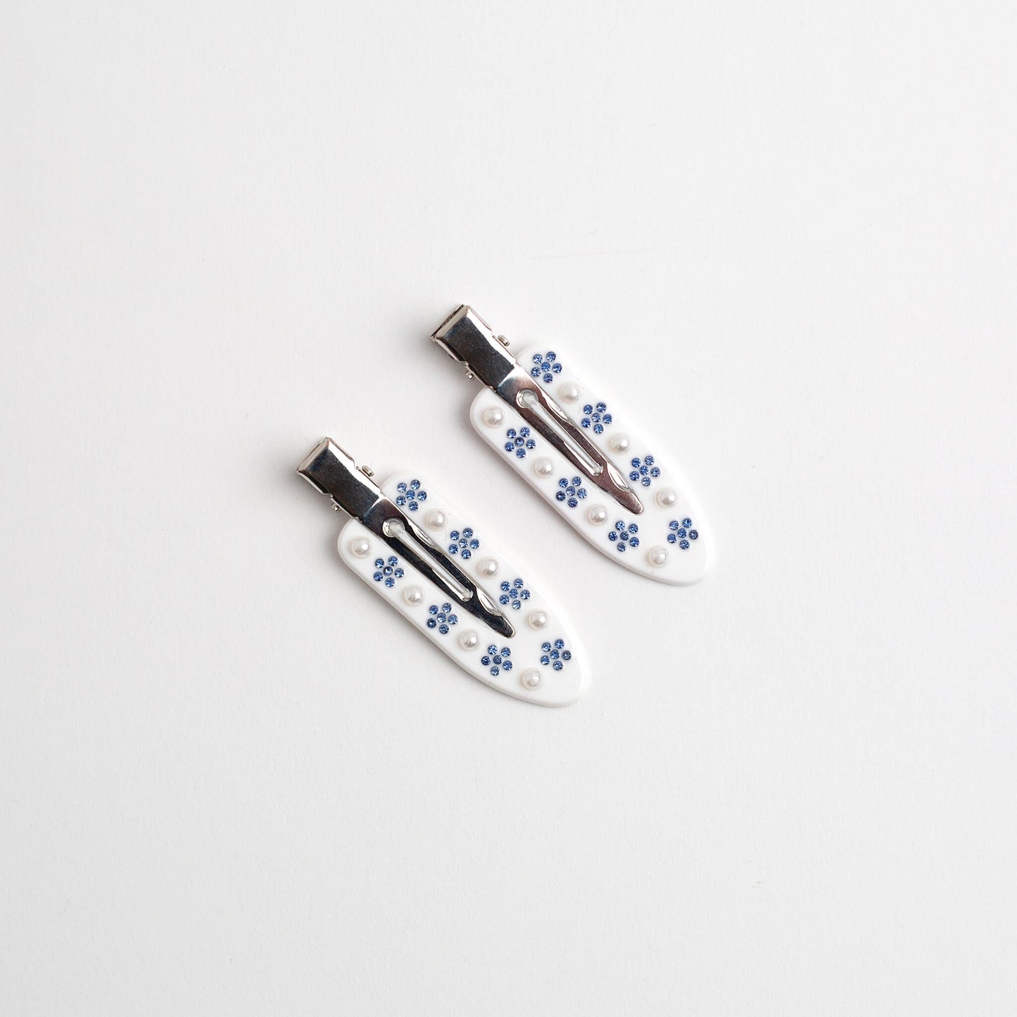 THOC Cove NO Crease Clips White with blue sparkly flower and pearl decoration on a white background.