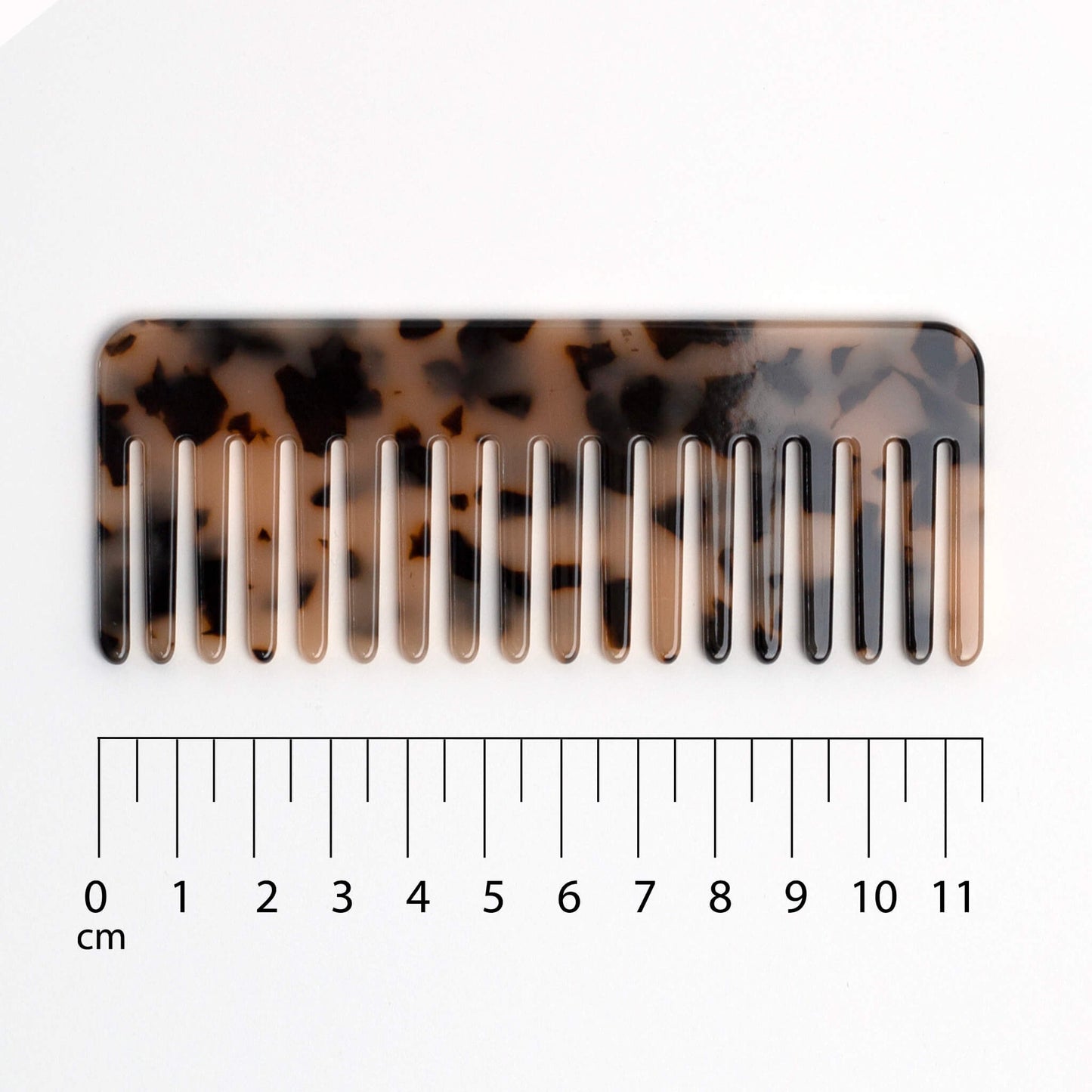 THOC Lila Travel Comb tortoiseshell-patterned comb with a ruler for scale on a white background