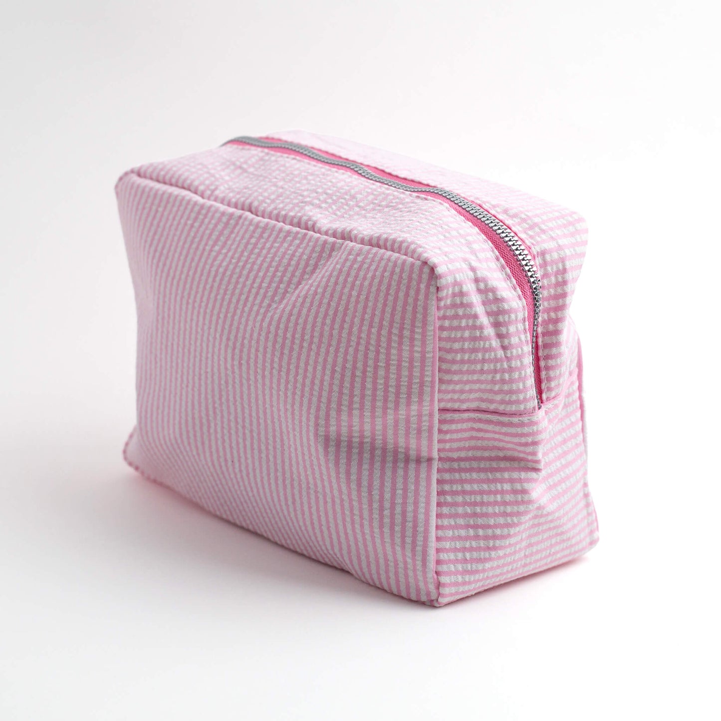 THOC Candy Beauty Bag Stripe pink upright at an angle on a white 
