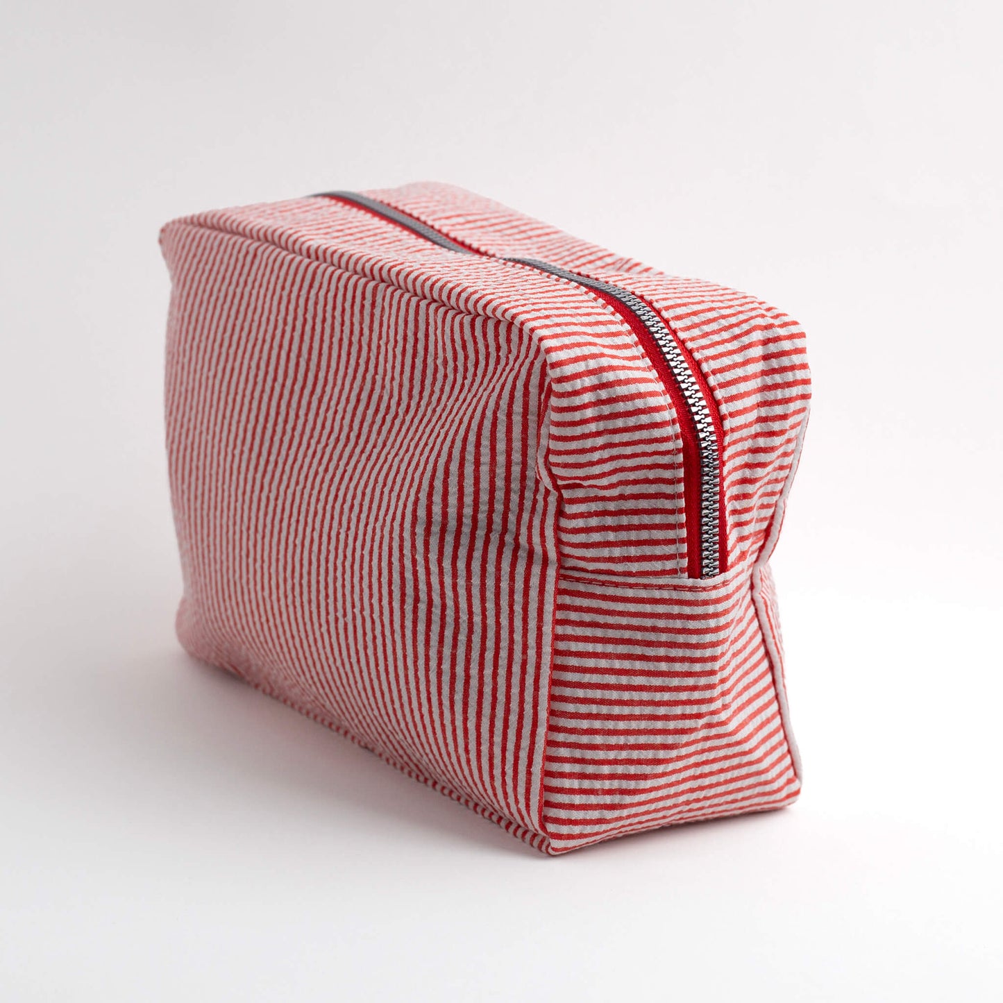 THOC Candy Beauty Bag Stripe red upright at an angle on a white background