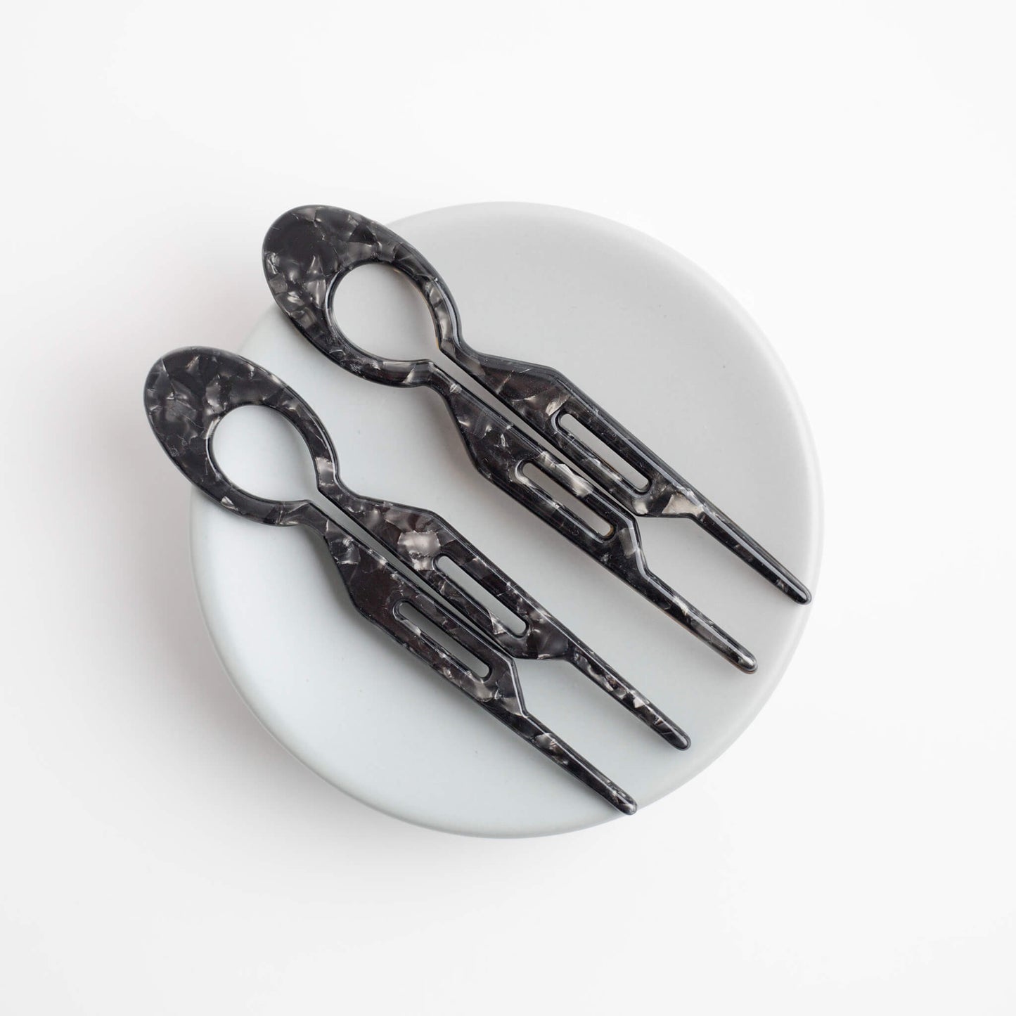 Two THOC Camille Hair Pin Black Coffee on a white dish with a white background