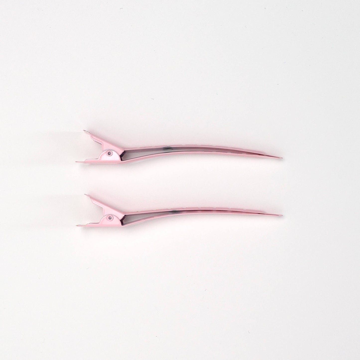Pair of THOC roller hair pins pink on a white background, side on