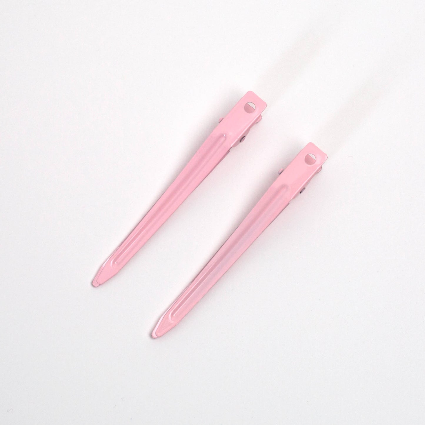 Pair of THOC roller hair pins pink on a white background, base facing up