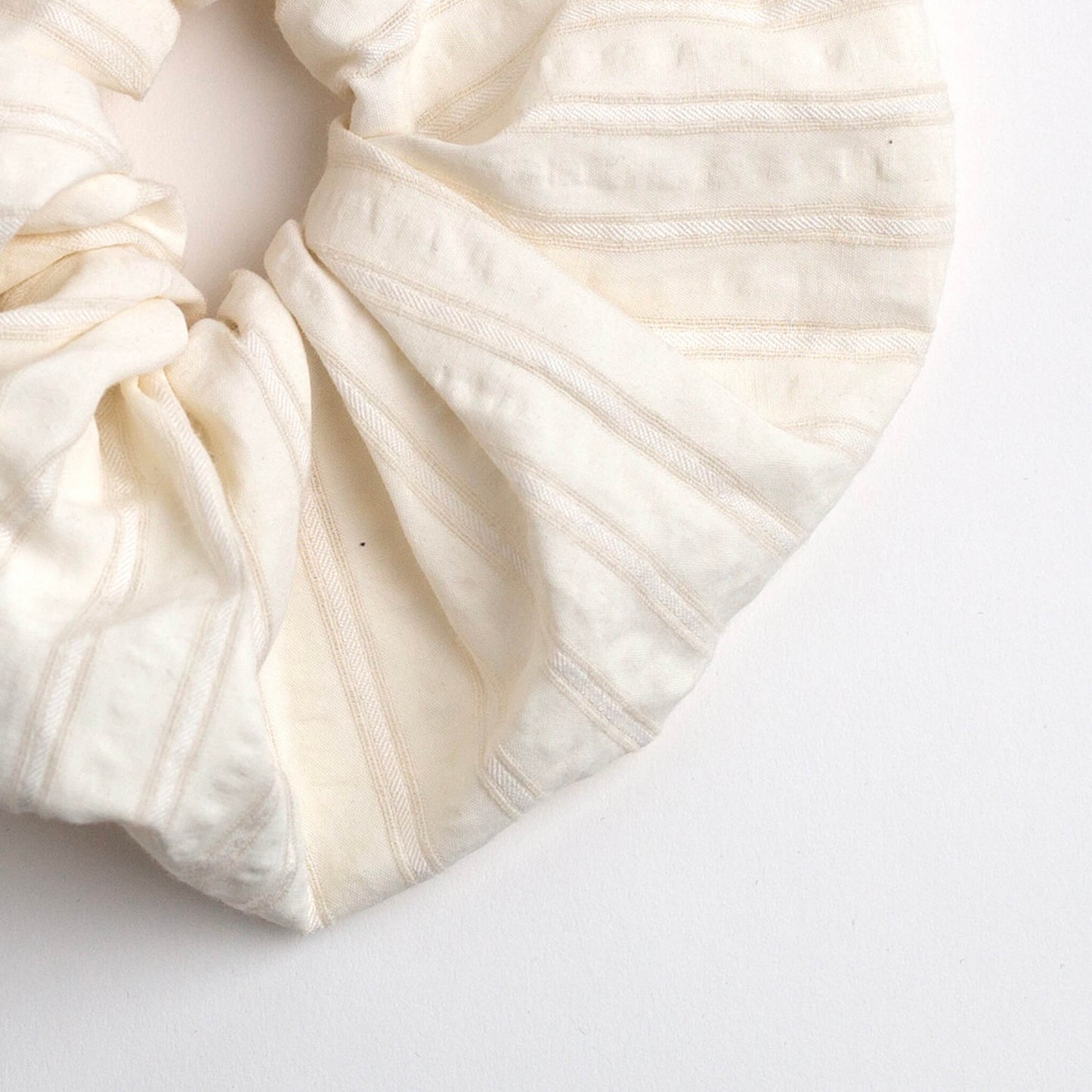 Close up of THOC Blush Stripe Scrunchie in Vanilla colour shown on a white background